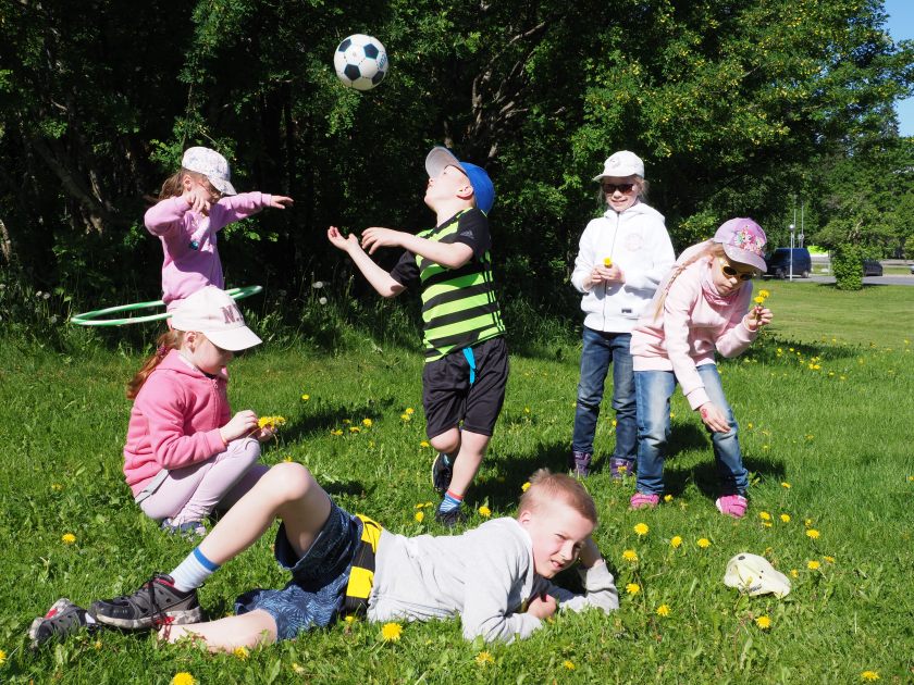 Kerholaiset leikkivät nurmikolla.