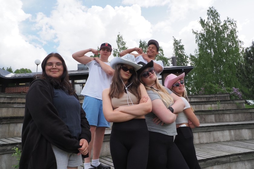 Viisi ippikoululaista ja isonen katsovat iloisesti kameraan.