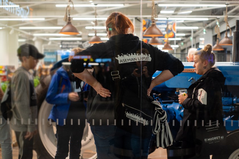 Kaksi nuorisotyön tekijää juttelee nuorten kanssa kauppakeskuksessa.