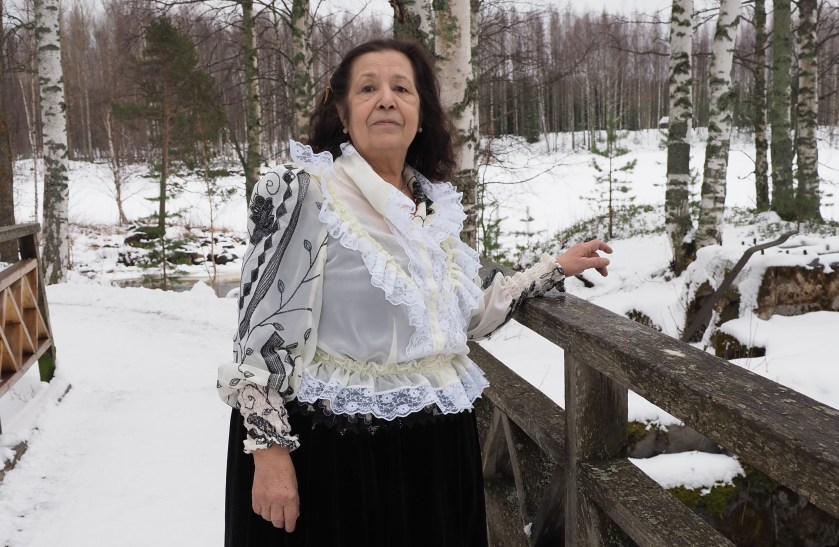 Sita Nyman seisoo ulkona sillalla talvimaisemassa.