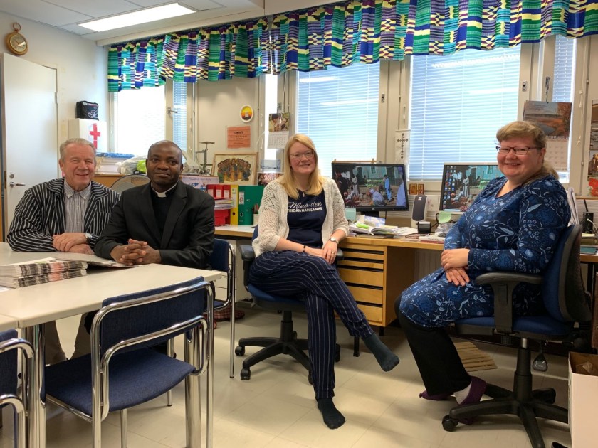 Heimo Karhapää, Gerson Mgaya, Mirkka Lammi ja Tuija Arday istuskelevat Pohjois-Karjalan Kansanlähetyksen toimistotiloissa.