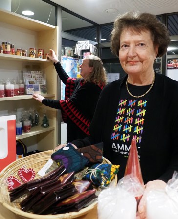 Paremman maailman puodin myyjä esittelee kuvassa tarjotinta, jossa on esillä myynnissä olevia tuotteita. 