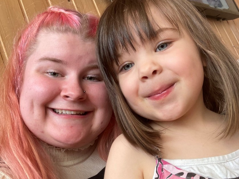 Nainen ja pieni tyttö hymyilevät kameralle.