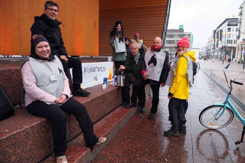 Joukko diakoniatyöntekijöitä, Sosiaaliturvayhdistyksen väkeä ja muita ihmisiä kokoontuneena Joensuun torilavan tuntumaan. Ihmisten keskellä Asunnottomien yön banderolli sekä kahvitermoksia.