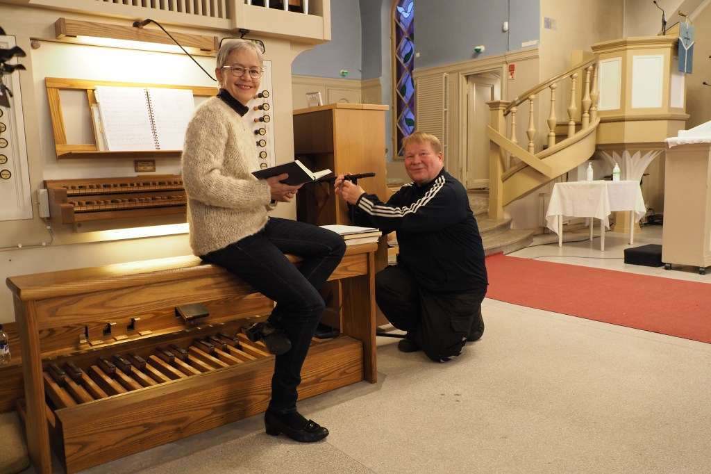 Kaksi ihmistä kirkon urkujen ympärillä.