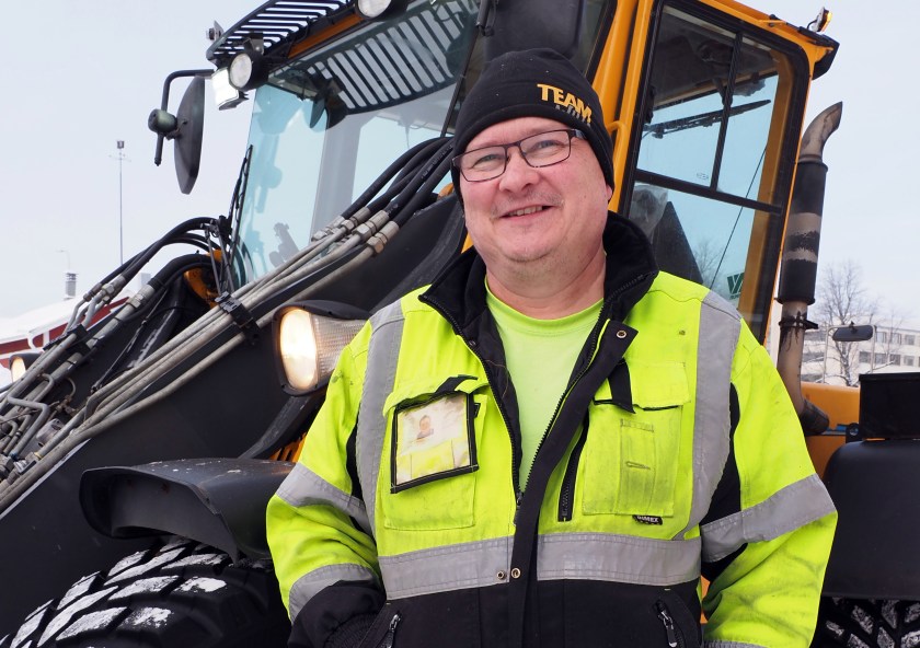 Auramies Pekka Kontu seisoo työvaatteissa Wille-lumitraktorinsa edessä ja katsoo hymyillen kameraan.
