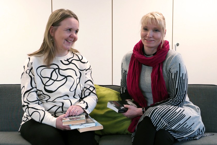 Miia Muhonen ja Hanna Pajarinen istuvat sohvalla runokirjat kädessään.