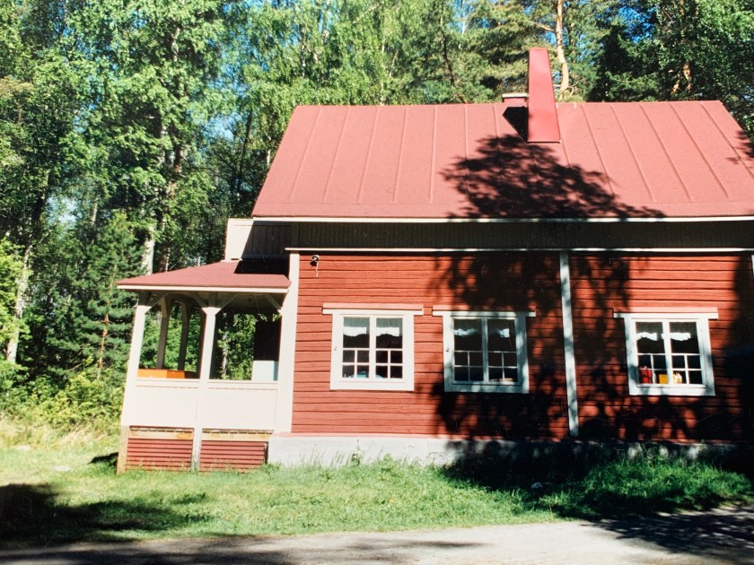 Sulkulan kesäkoti kesäisessä auringonpaisteessa. Sulkulan kesäkoti on punamullalla maalattu vanha hirsirakennus. 